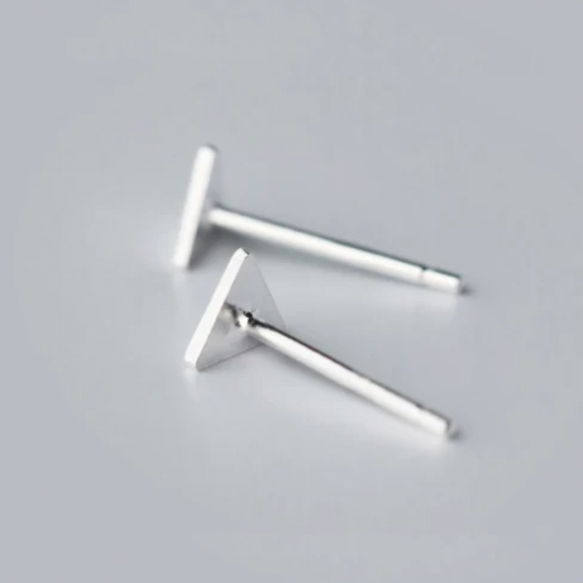 Angled view of a flat triangle stud earring - Let's Jam jewellery, Camden Market