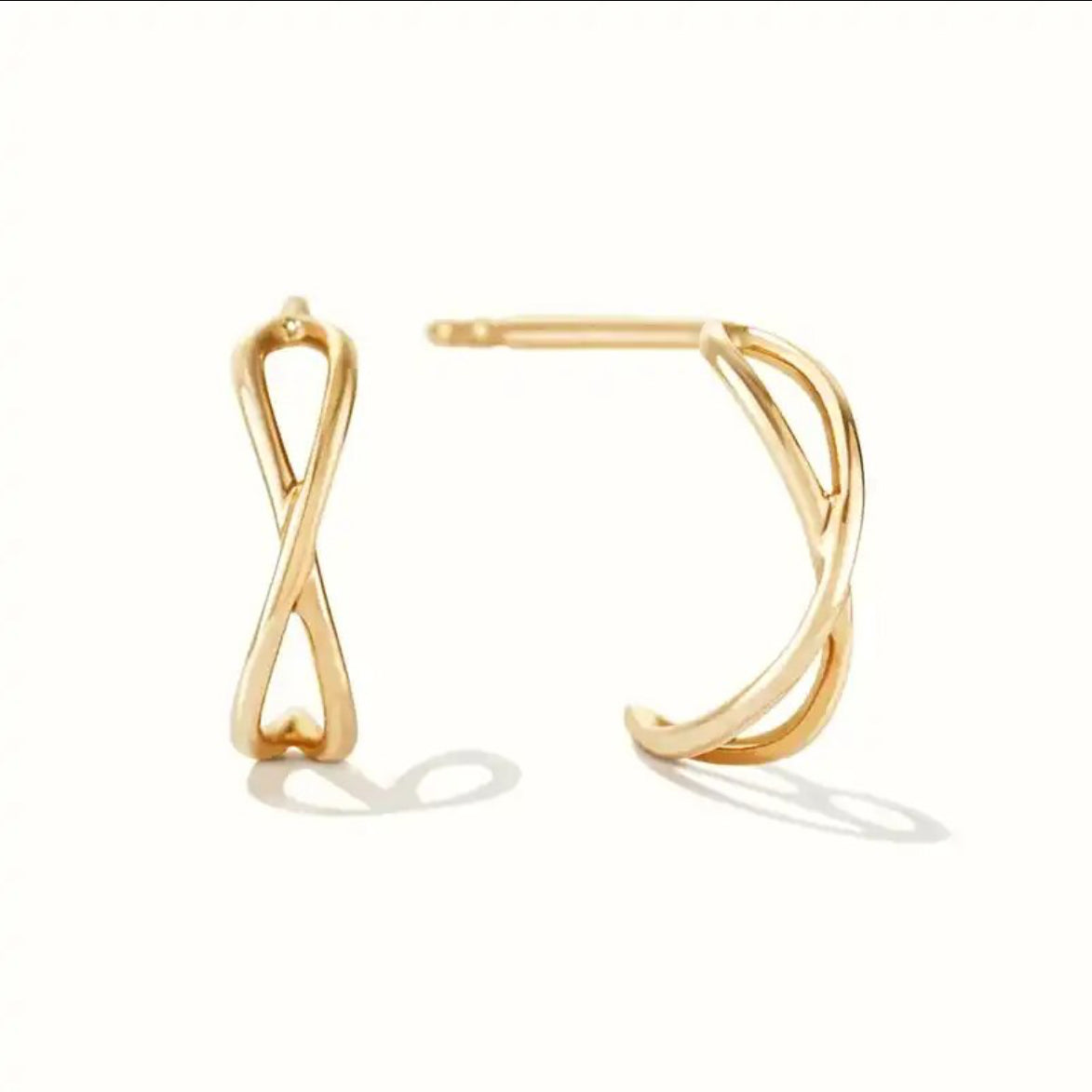 Pair of gold-plated stud earrings, one shaped like an infinity symbol and the other an open swirling curve, on a white background - Let's Jam jewellery collection