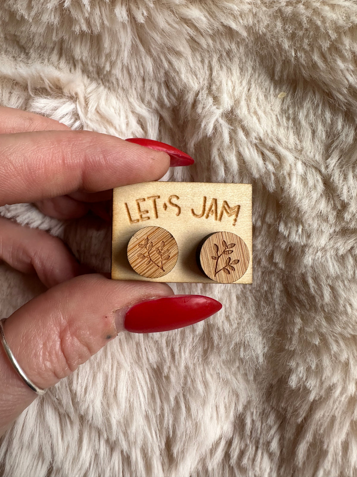 Close-up of the fine sprig engraving on light wooden earrings - Let's Jam, Camden Town