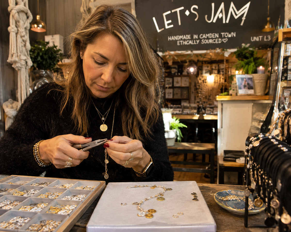 Jeweller making jewellery at the workbench under the shop sign - Let's Jam, Camden Town London