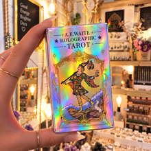 Load image into Gallery viewer, A hand holds a holographic tarot card deck box labeled 'A.E.
