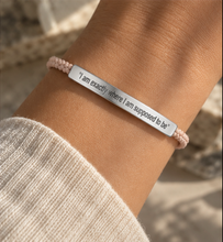 Load image into Gallery viewer, A close-up of a person's wrist wearing a light pink beaded bracelet with a polished silver metal ID bar engraved with the quote, "I am exactly where I am supposed to be.".
