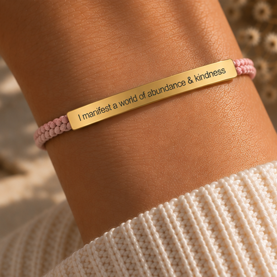Pink cord bracelet with a gold abundance and kindness bar, worn on the wrist - Let's Jam jewellery, Camden Market