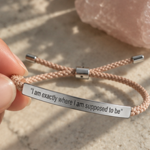Load image into Gallery viewer, Hand holding a braided cord bracelet with a silver engraved bar - Let's Jam jewellery, Camden Market, London
