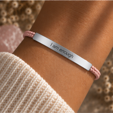 Load image into Gallery viewer, Silver I Am Enough bar with a pale pink beaded cord, worn on the wrist - Let's Jam, Camden Market London
