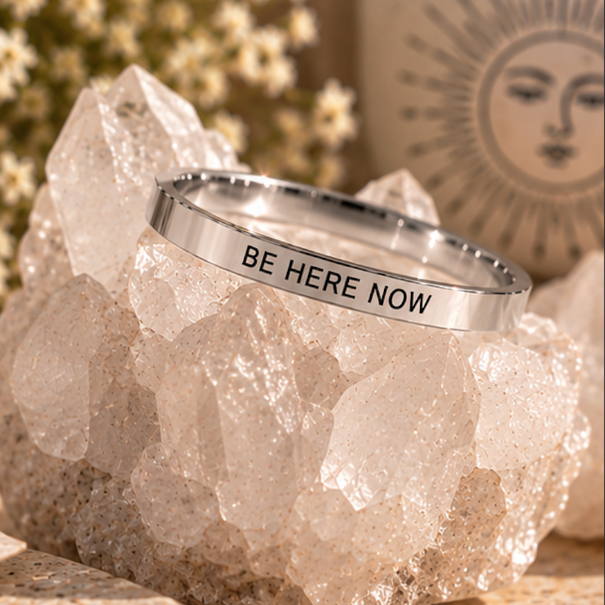 Silver affirmation ring engraved 'Be here now' displayed on quartz - Let's Jam jewellery, Camden Market