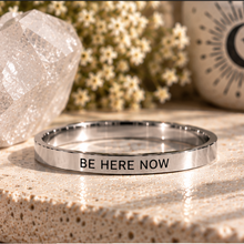 Load image into Gallery viewer, Silver 'Be here now' affirmation ring on a stone surface with a crystal - Let's Jam, Camden Town London
