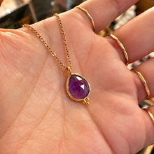 Load image into Gallery viewer, Faceted purple amethyst tear drop pendant in a gold setting held in the hand - Let's Jam, Camden Market

