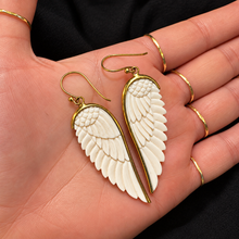 Load image into Gallery viewer, White angel wing earrings on brass fish hooks held in the palm - Let's Jam jewellery, Camden Town London

