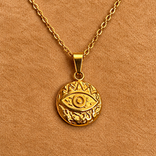 Load image into Gallery viewer, Round gold medallion with an open third eye and rays on a chain - Let's Jam, Camden Market, London
