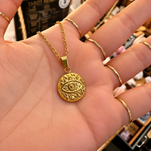 Load image into Gallery viewer, Gold awaken third eye medallion held in the hand - Let's Jam, Camden Market
