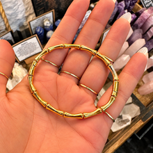 Load image into Gallery viewer, Gold bamboo bangle held in the hand - Let's Jam, Camden Market London
