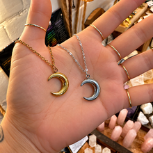 Load image into Gallery viewer, Gold and silver big crescent moon pendants held in the hand - Let's Jam jewellery, Camden Town
