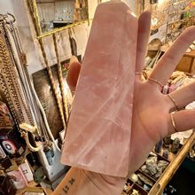 Load image into Gallery viewer, Big rose quartz point held in the hand to show its size - Let's Jam, Camden Market, London
