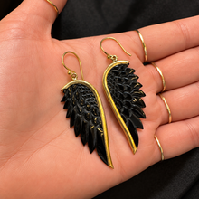 Load image into Gallery viewer, Black angel wing earrings on brass fish hooks held in the palm - Let's Jam jewellery, Camden Market
