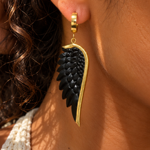 Load image into Gallery viewer, Black carved angel wing earring edged in gold, worn close up - Let's Jam jewellery, Camden Market London
