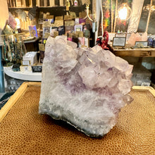 Load image into Gallery viewer, Raw Brazilian amethyst held in the hand to show its size - Let's Jam, Camden Market, London
