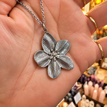 Load image into Gallery viewer, Silver cherry blossom flower pendant held in the hand - Let's Jam, Camden Market London
