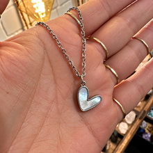 Load image into Gallery viewer, Silver cute mother of pearl heart pendant held in the hand - Let's Jam, Camden Market
