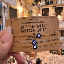 Load image into Gallery viewer, Gold and silver evil eye matching bracelets on a Let's Keep An Eye On Each Other card - Let's Jam, Camden Market London
