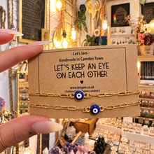 Load image into Gallery viewer, Two gold evil eye matching bracelets on a Let's Keep An Eye On Each Other card - Let's Jam, Camden Market
