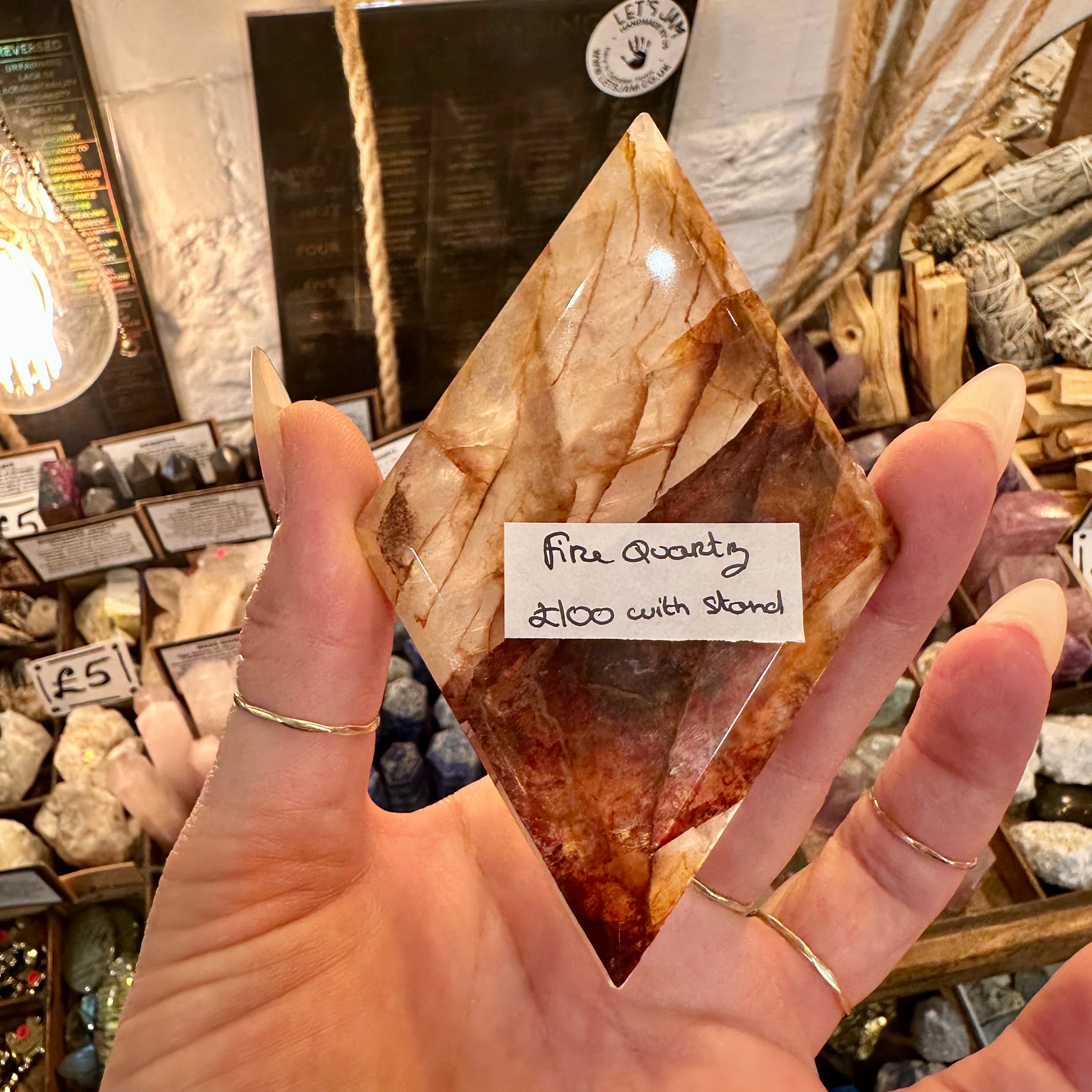 Fire quartz crystal freeform held in the hand in the shop - Let's Jam, Camden Town