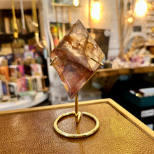Load image into Gallery viewer, Fire quartz on its gold stand in the shop, side angle - Let's Jam, Camden Town London
