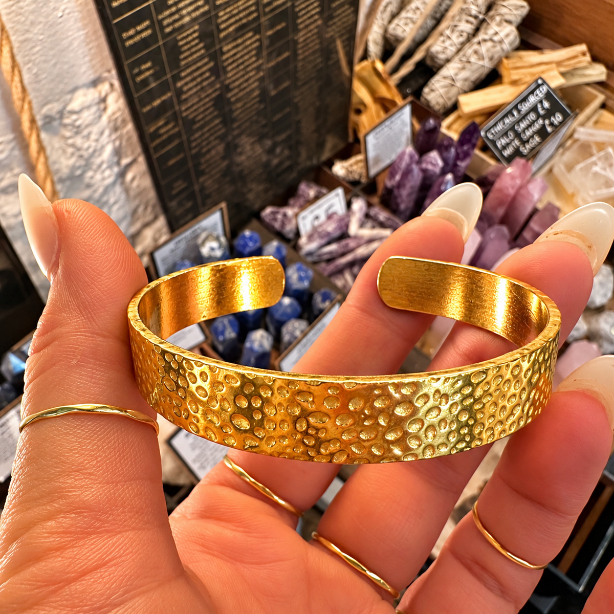 Front of the hammered gold cuff held up - Let's Jam jewellery, Camden Market, London