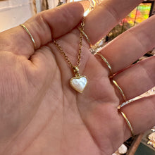 Load image into Gallery viewer, Gold framed mother of pearl heart pendant held in the hand - Let's Jam, Camden Market, London
