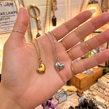 Load image into Gallery viewer, Gold and silver puffed heart necklaces held in the hand - Let's Jam, Camden Town
