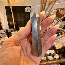 Load image into Gallery viewer, Metallic hematite tower held in the hand to show its size - Let's Jam, Camden Market, London
