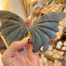 Load image into Gallery viewer, Labradorite butterfly wings held in the hand to show their size - Let's Jam, Camden Market, London
