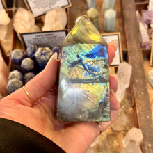 Load image into Gallery viewer, Labradorite crystal point glowing blue and yellow in the palm - Let's Jam, Camden Town London
