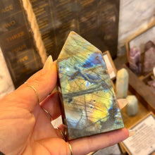 Load image into Gallery viewer, Labradorite obelisk held in the hand, flashing blue and gold - Let's Jam, Camden Market
