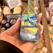 Load image into Gallery viewer, Polished labradorite point held up in the crystal shop - Let's Jam, Camden Town
