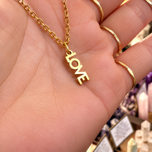 Load image into Gallery viewer, Gold LOVE word necklace held in the hand - Let's Jam, Camden Town London
