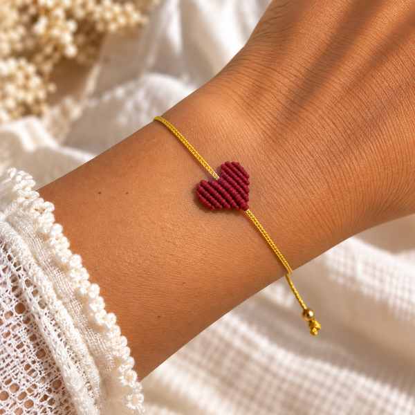 Dark red macramé heart bracelet on a gold cord, worn on the wrist - Let's Jam, Camden Market