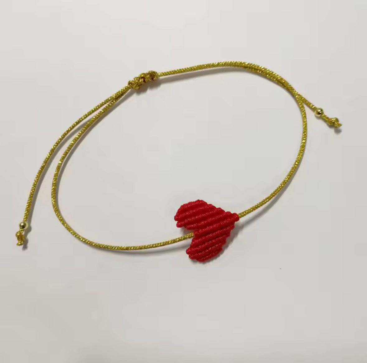 Red macramé heart bracelet showing the adjustable sliding knot cord - Let's Jam, Camden Market London