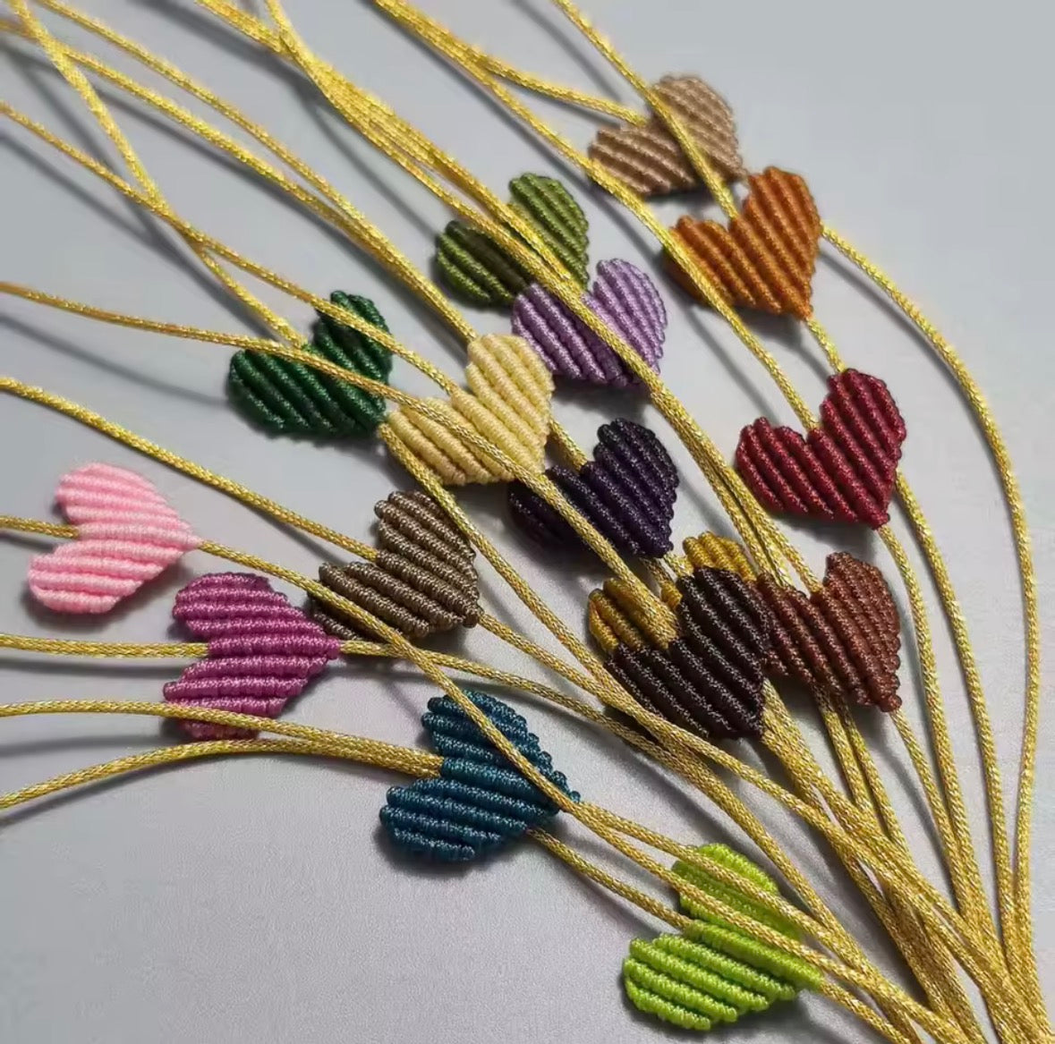 Bunch of macramé heart bracelets in many colours on gold cords - Let's Jam, Camden Town