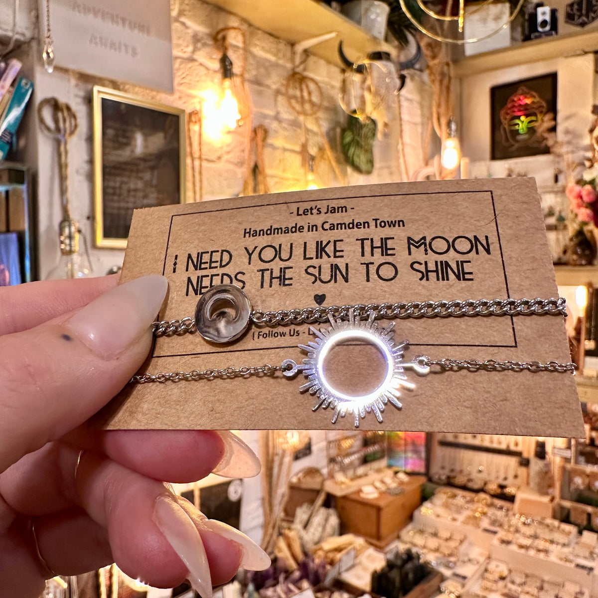 Moon and sun matching bracelets on their card, held up in the shop - Let's Jam, Camden Market London