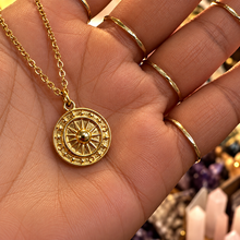 Load image into Gallery viewer, Gold sun and moon medal with a star border held in the hand - Let's Jam, Camden Market, London
