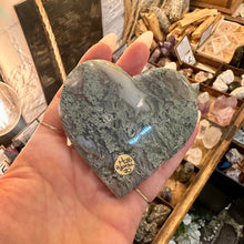 Load image into Gallery viewer, Side view of the moss agate heart resting on its wooden stand - Let's Jam, Camden Market London
