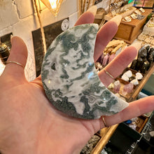 Load image into Gallery viewer, Moss agate moon crescent held in the hand in the shop - Let's Jam, Camden Market London
