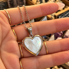 Load image into Gallery viewer, Silver mother of pearl heart locket held in the hand - Let's Jam, Camden Market, London
