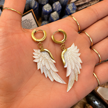 Load image into Gallery viewer, Pair of carved mother of pearl wing earrings held in the palm - Let's Jam, Camden Market
