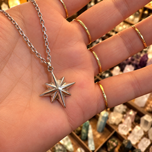 Load image into Gallery viewer, Silver northern star pendant held in the hand - Let's Jam jewellery, Camden Town
