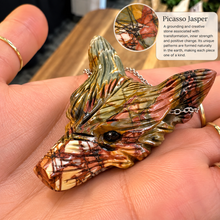 Load image into Gallery viewer, Picasso jasper wolf pendant in the hand beside its crystal card - Let's Jam, Camden Market London
