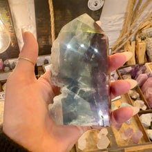 Load image into Gallery viewer, Rainbow fluorite tower held up to the light to show its colours - Let's Jam, Camden Town London
