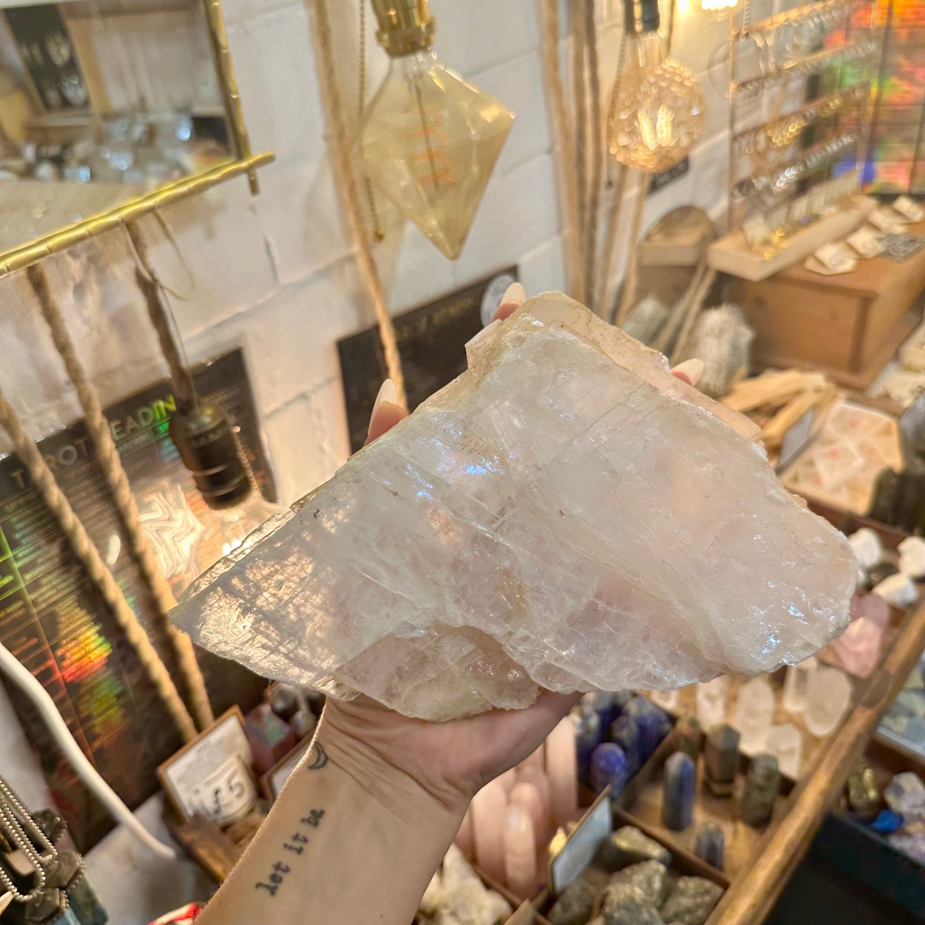 Raw calcite crystal chunk held in the hand to show its size - Let's Jam, Camden Town