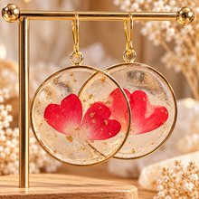 Load image into Gallery viewer, Round resin earrings with real red heart petals and gold flecks hanging on a gold stand - Let's Jam, Camden Market
